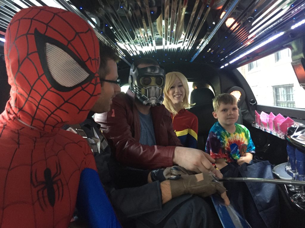 Superheroes with a Wish Kid in a limo